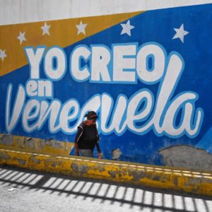 A woman wearing a face mask walks past a painted wall that reads "I believe in Venezuela" in Caracas, on January 5, 2021. - The new Venezuelan parliament was sworn this Tuesday with President Nicolas Maduro's party now in almost complete control and Western-backed opposition leader Juan Guaido out in the political cold. (Photo by Federico PARRA / AFP) (Photo by FEDERICO PARRA/AFP via Getty Images)
