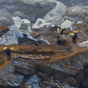 Indonesian sulfur miner carrying their 90-kg-load of sulfur from the floor of the volcano to crater rim