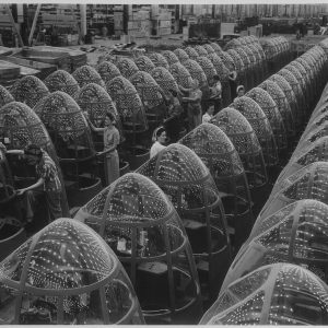 Stars over Berlin and Tokyo will soon replace these factory lights reflected in the noses of planes at Douglas Aircraft's Long Beach, Calif., plant. Women workers groom lines of transparent noses for deadly A-20 attack bombers